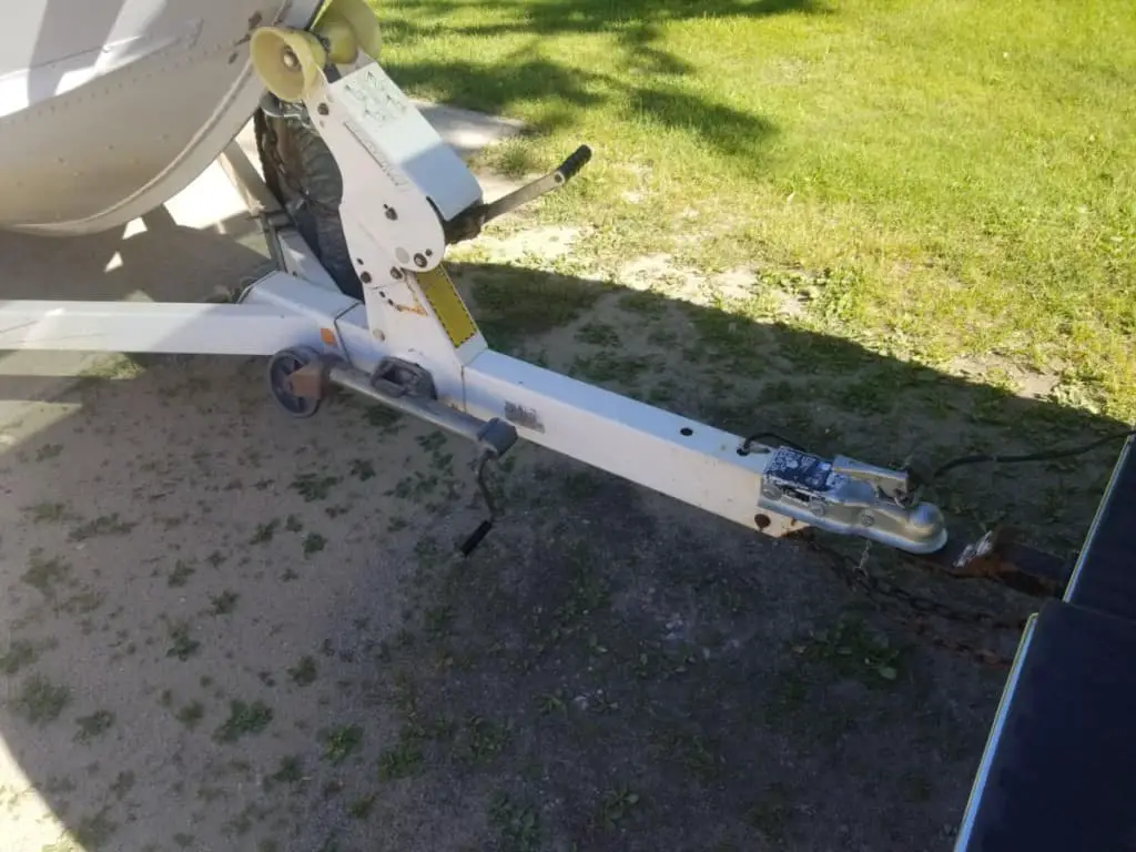 image of a cuddy cabin boat on a trailer that is attached to a truck's hitch for towing.