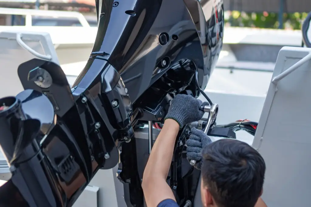 image of boat owner maintaining his outboard engine to maintain fuel efficiency