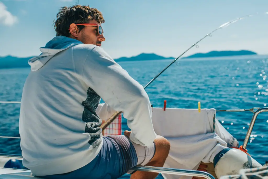 man fishing on a boat with sunglasses