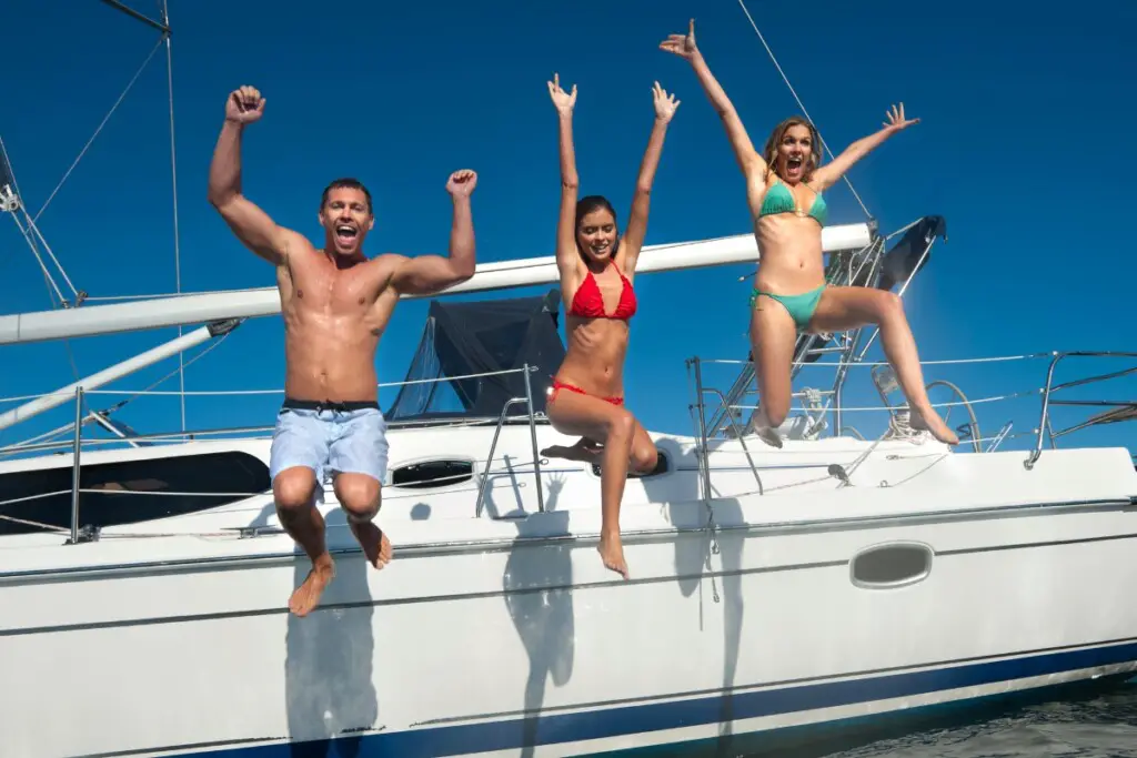 image of friends jumping off boat into the water