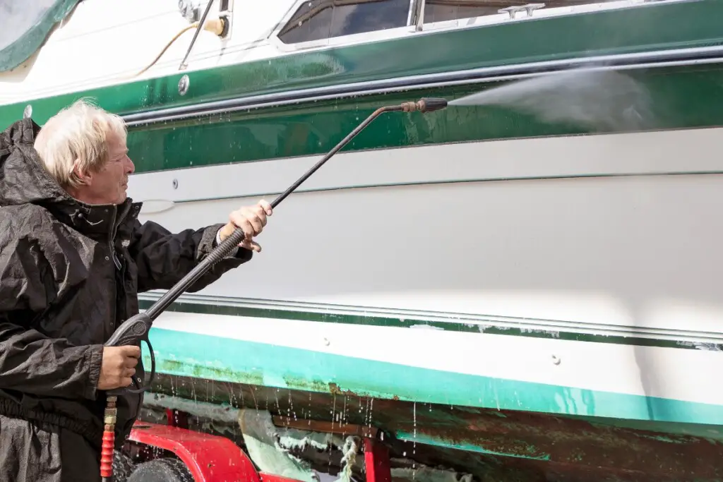 image of a man power washing the starboard side of a boat